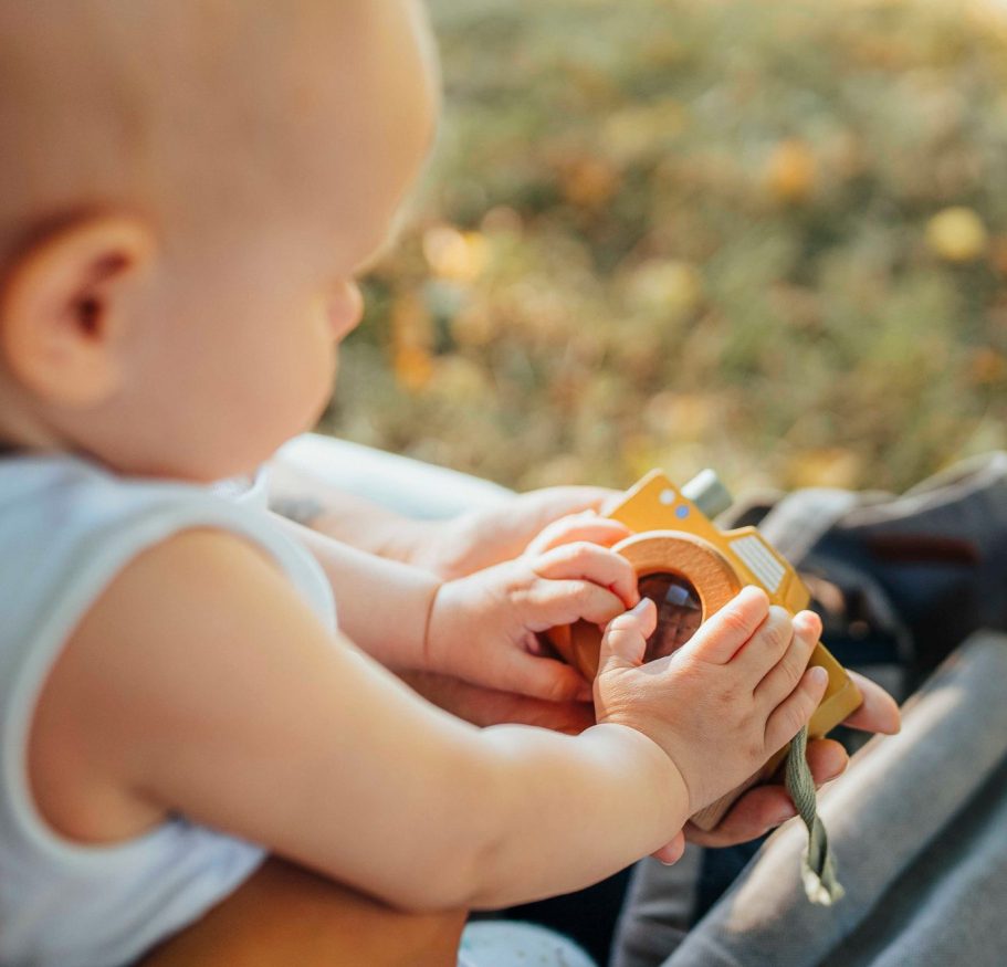 Familienfotos in Main Spessart Ein Kleinkind hält eine gelbe Spielzeugkamera im Freien.