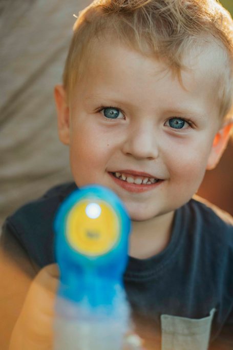 Fotograf Main Spessart und Umgebung Ein strahlender Junge lächelt und hält eine Wasserpistole in der Hand.